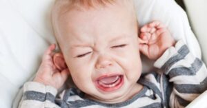 Baby pulling at his ears and crying